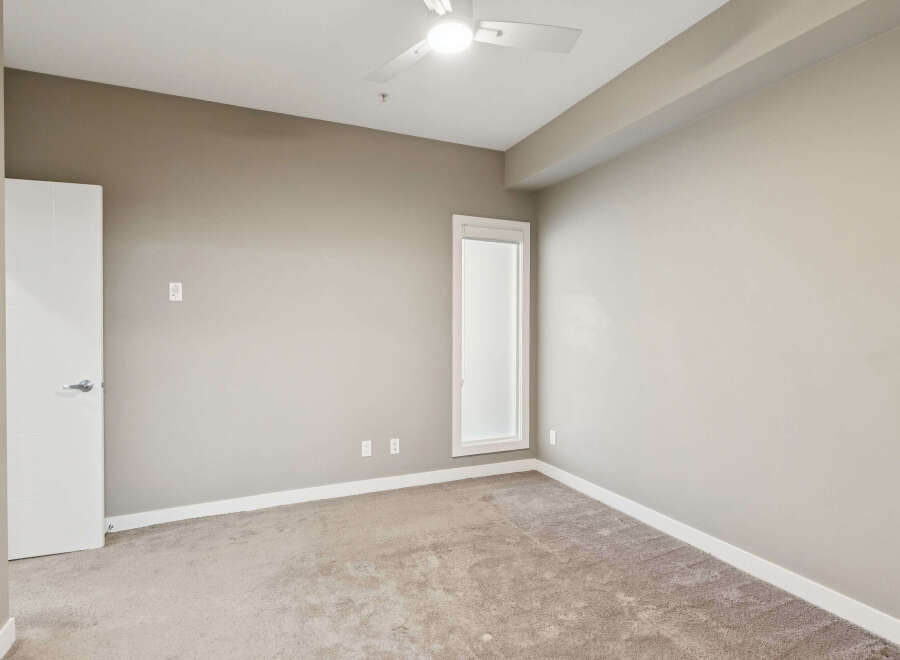 This spacious bedroom features a neutral color palette, creating a serene and inviting atmosphere.