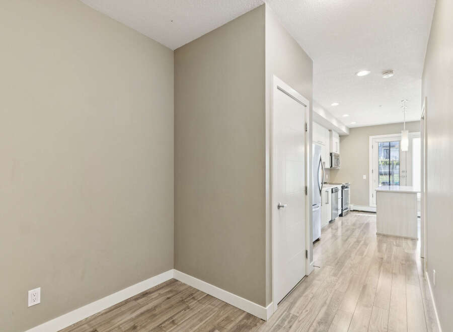 Step into this inviting hallway, featuring a sleek white door and a neutral-toned wall that sets a modern and clean aesthetic.