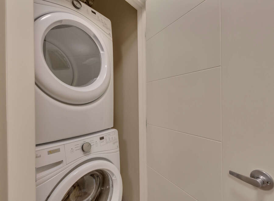 Discover the convenience of in-suite laundry with this stacked washer and dryer unit, perfect for maximizing space in your home.
