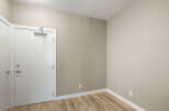 Step into this inviting space featuring a sleek white door with modern hardware, leading into a room with neutral-toned walls and a warm, wood-look laminate floor.