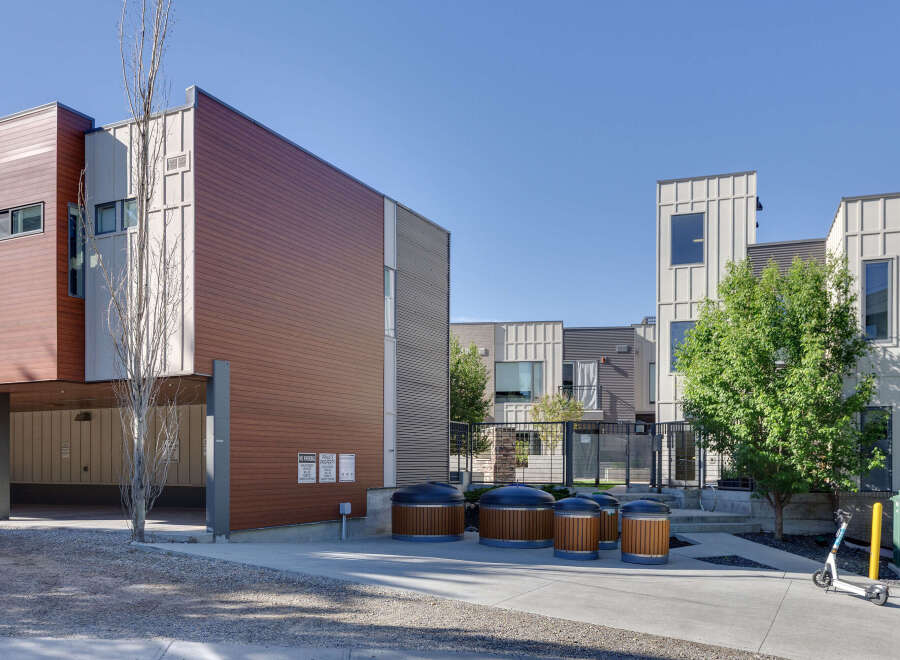 Discover modern living in this contemporary townhome complex, featuring striking architectural design with warm wood accents and sleek metal siding.