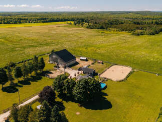 Discover this stunning rural estate featuring a spacious barn, a charming residence, and a dedicated riding arena perfect for equestrian enthusiasts.