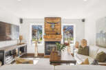 Experience rustic charm in this inviting living room, featuring a striking wooden fireplace adorned with a longhorn skull.
