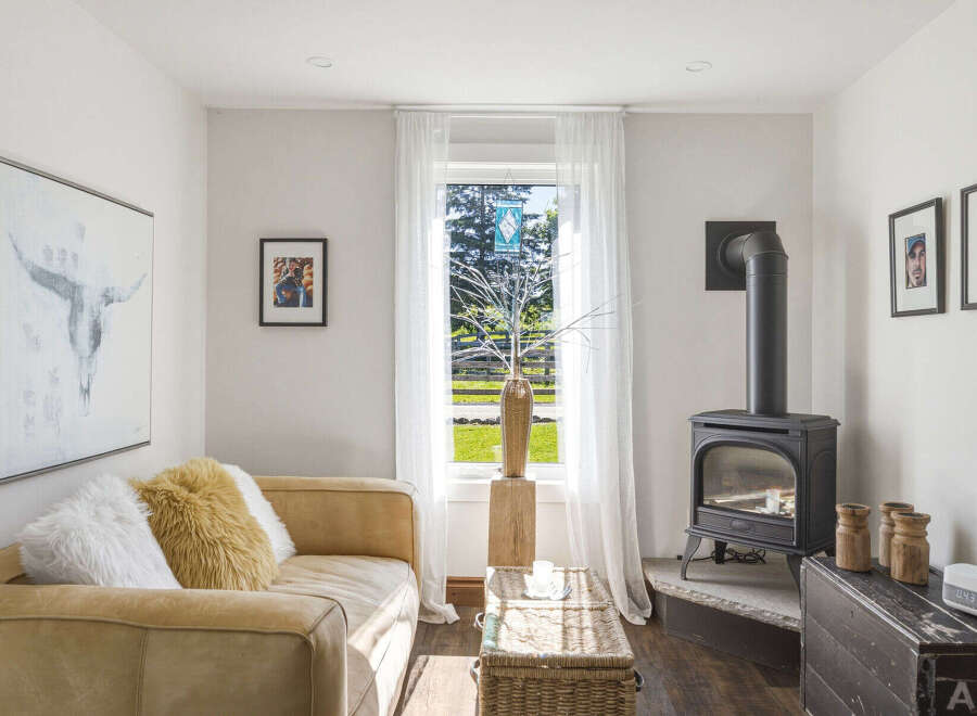 Cozy living room featuring a plush tan sofa adorned with fluffy pillows, perfect for relaxation.