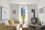 Cozy living room featuring a plush tan sofa adorned with fluffy pillows, perfect for relaxation.