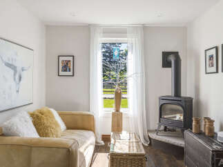 Cozy living room featuring a plush tan sofa adorned with fluffy pillows, perfect for relaxation.