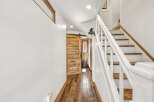 This charming home features a rustic wooden barn door leading to a bright interior.