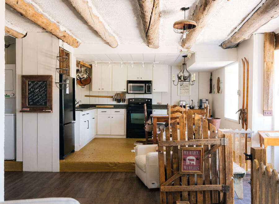 Step into a charming rustic retreat featuring exposed wooden beams and a cozy kitchen area.