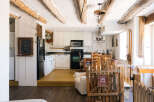 Step into a charming rustic retreat featuring exposed wooden beams and a cozy kitchen area.