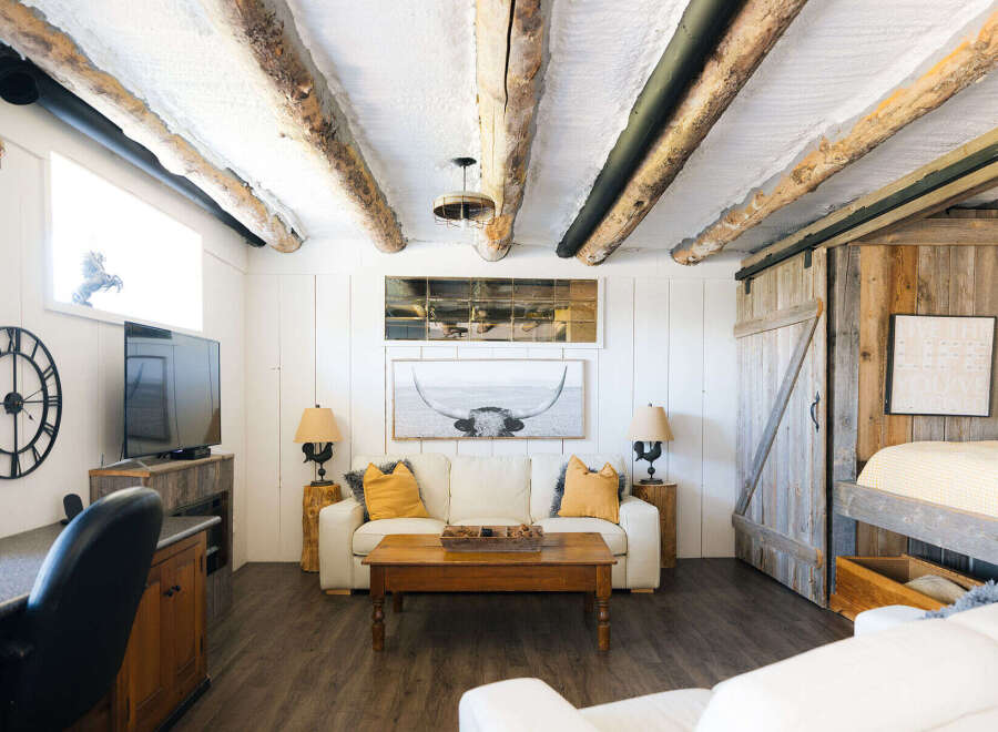 Experience rustic charm and modern comfort in this unique living space, featuring exposed log beams and a cozy farmhouse aesthetic.