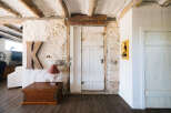 Discover rustic charm in this unique living space, featuring exposed wooden beams and textured stone walls that add character and warmth.