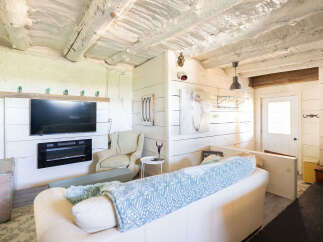 Experience rustic charm in this cozy living space featuring a modern electric fireplace and a large flat-screen TV mounted above.