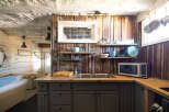 Discover this charming kitchen featuring rustic corrugated metal walls and a butcher block countertop.