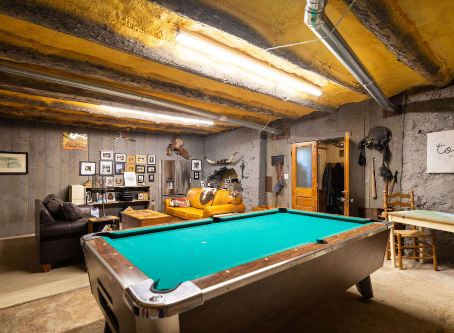 Experience rustic charm in this unique recreational space, featuring a vibrant pool table perfect for game nights.