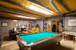 Experience rustic charm in this unique recreational space, featuring a vibrant pool table perfect for game nights.
