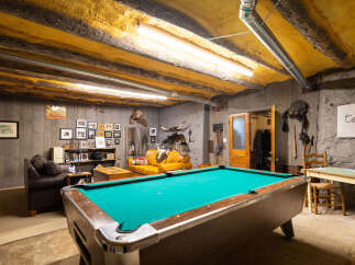 Experience rustic charm in this unique recreational space, featuring a vibrant pool table perfect for game nights.