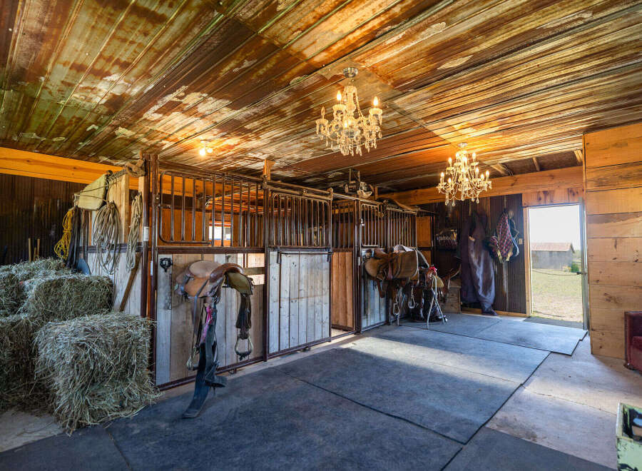 Step into this charming rustic barn, featuring multiple horse stalls and ample hay storage, perfect for equestrian enthusiasts.