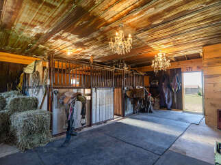 Step into this charming rustic barn, featuring multiple horse stalls and ample hay storage, perfect for equestrian enthusiasts.