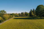 Discover this stunning property featuring a vast, sun-drenched green lawn perfect for outdoor activities and relaxation.