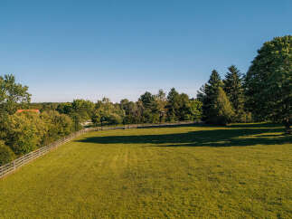 Discover this stunning property featuring a vast, sun-drenched green lawn perfect for outdoor activities and relaxation.