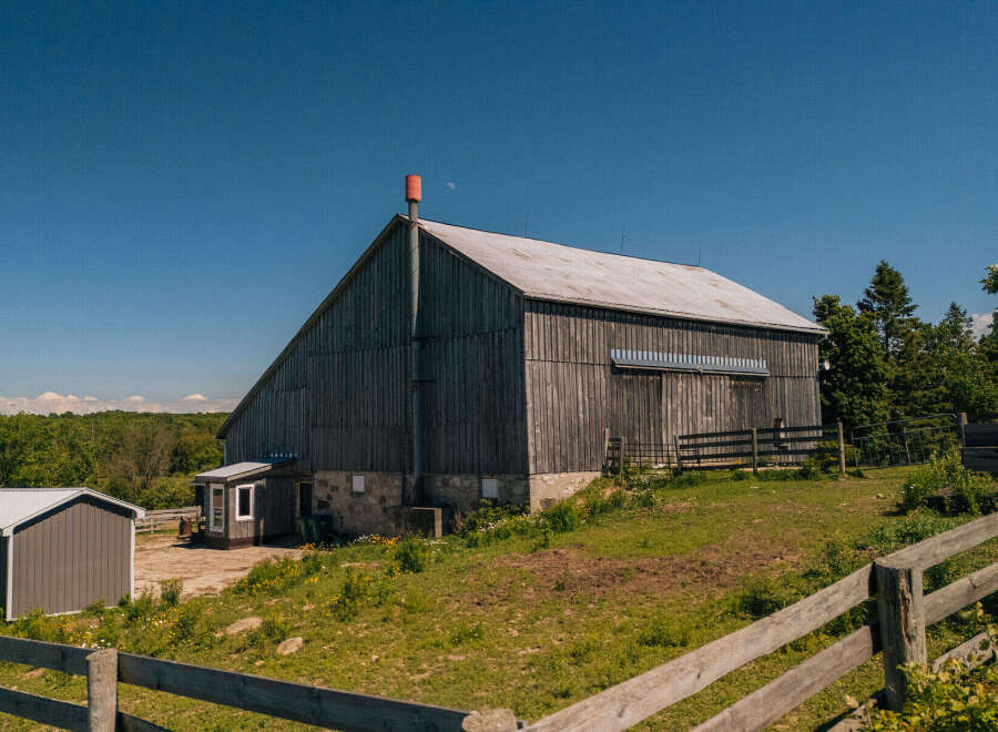 Discover this charming rural property featuring a classic wooden barn with a metal roof, perfect for agricultural use or conversion into a unique event space.