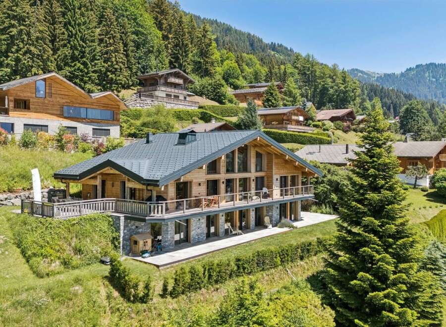 Experience luxury mountain living in this stunning chalet, featuring expansive glass windows that flood the interior with natural light and offer breathtaking panoramic views.