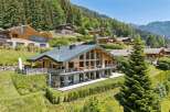 Experience luxury mountain living in this stunning chalet, featuring expansive glass windows that flood the interior with natural light and offer breathtaking panoramic views.
