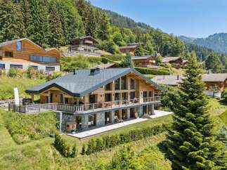 Experience luxury mountain living in this stunning chalet, featuring expansive glass windows that flood the interior with natural light and offer breathtaking panoramic views.