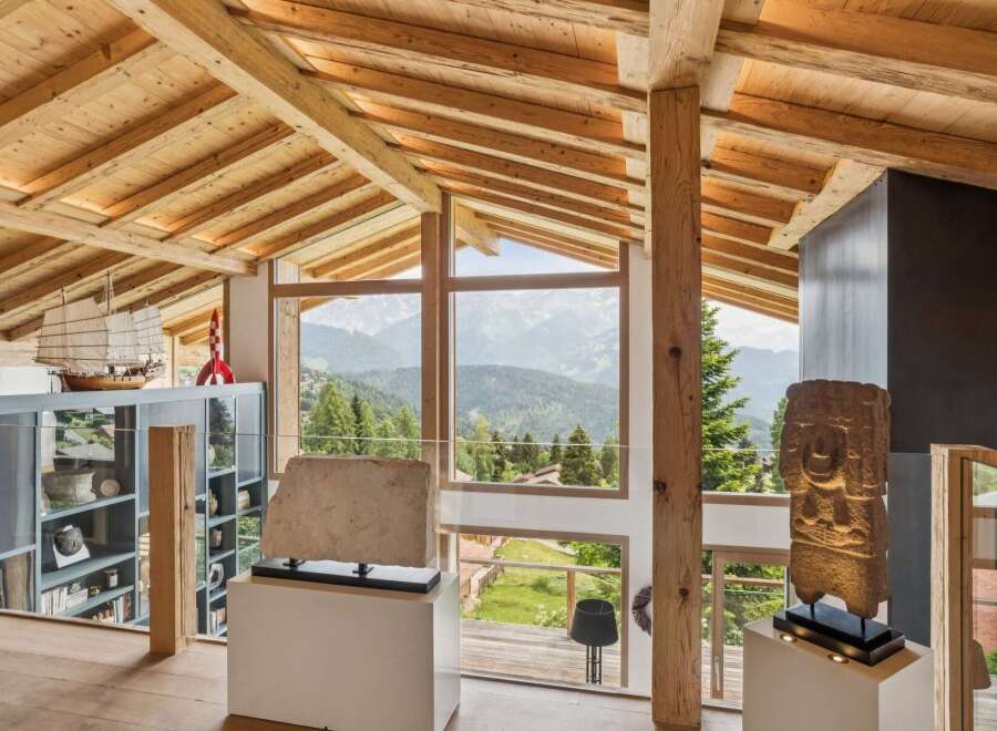 Experience breathtaking mountain views from this stunning architectural masterpiece, featuring exposed wooden beams and expansive windows that flood the space with natural light.
