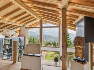 Experience breathtaking mountain views from this stunning architectural masterpiece, featuring exposed wooden beams and expansive windows that flood the space with natural light.