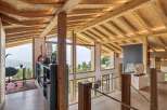 Experience breathtaking mountain views from this stunning chalet, featuring a spacious open-plan living area with exposed wooden beams and a vaulted ceiling.