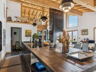Experience luxury living in this stunning open-concept kitchen and dining area, featuring a spacious wooden island perfect for entertaining.