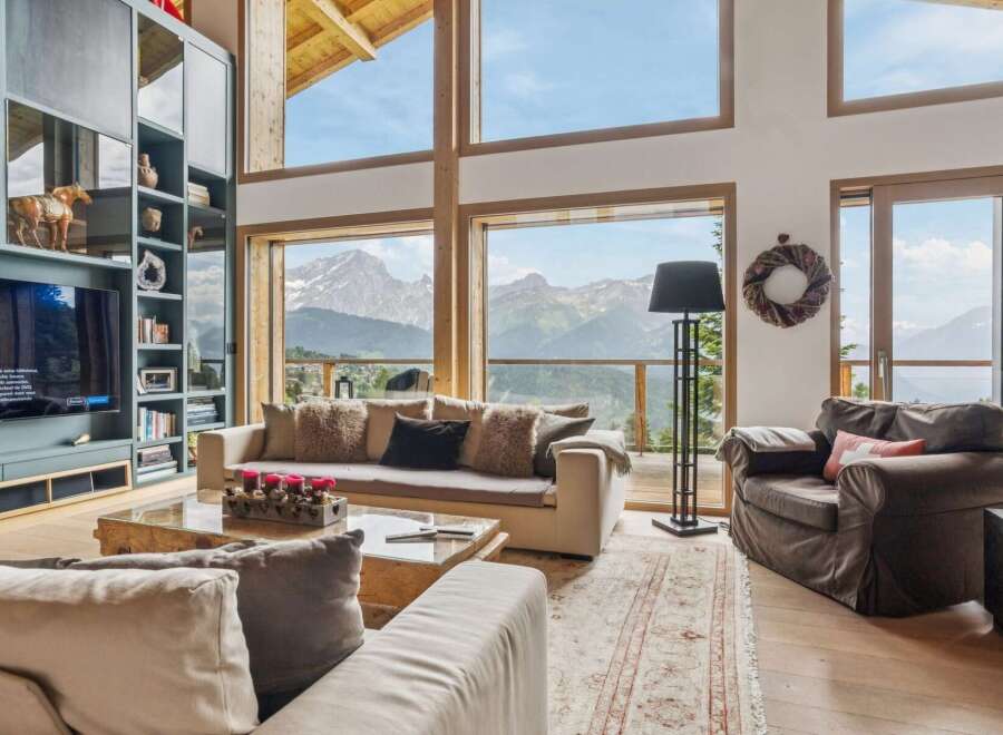 Experience breathtaking mountain views from this luxurious living room, featuring a grand fireplace and expansive windows that bring the outdoors in.