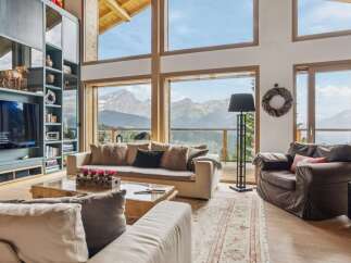 Experience breathtaking mountain views from this luxurious living room, featuring a grand fireplace and expansive windows that bring the outdoors in.