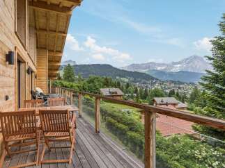 Experience breathtaking mountain views from this stunning wooden balcony, perfect for enjoying your morning coffee or evening wine.