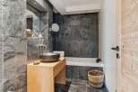 Experience modern luxury in this stunning bathroom featuring a sleek, dark stone tile design.