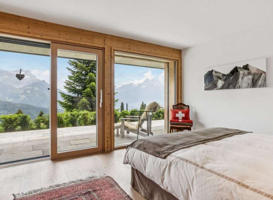Experience breathtaking mountain views from this serene bedroom, featuring expansive sliding glass doors that open to a private balcony.