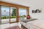 Experience breathtaking mountain views from this serene bedroom, featuring expansive sliding glass doors that open to a private balcony.