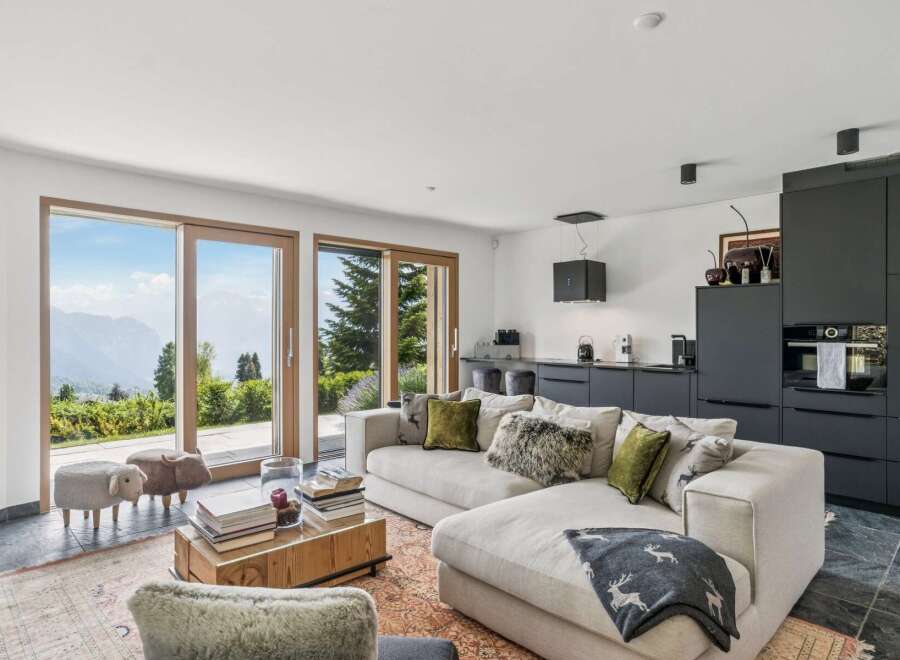 Experience breathtaking mountain views from this modern living space, featuring expansive sliding glass doors that seamlessly connect the interior to the stunning natural landscape.