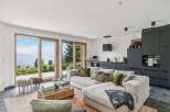 Experience breathtaking mountain views from this modern living space, featuring expansive sliding glass doors that seamlessly connect the interior to the stunning natural landscape.