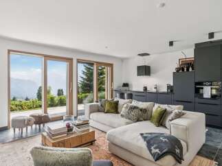 Experience breathtaking mountain views from this modern living space, featuring expansive sliding glass doors that seamlessly connect the interior to the stunning natural landscape.