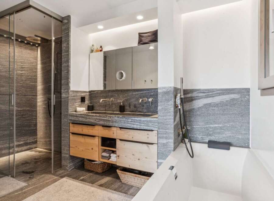 Experience modern luxury in this stunning bathroom featuring a spacious walk-in shower with sleek stone tilework and a rainfall showerhead.