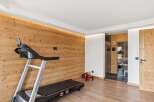 This modern gym area features a Pro-Form treadmill set against a warm, wood-paneled wall with ambient lighting.