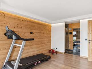 This modern gym area features a Pro-Form treadmill set against a warm, wood-paneled wall with ambient lighting.