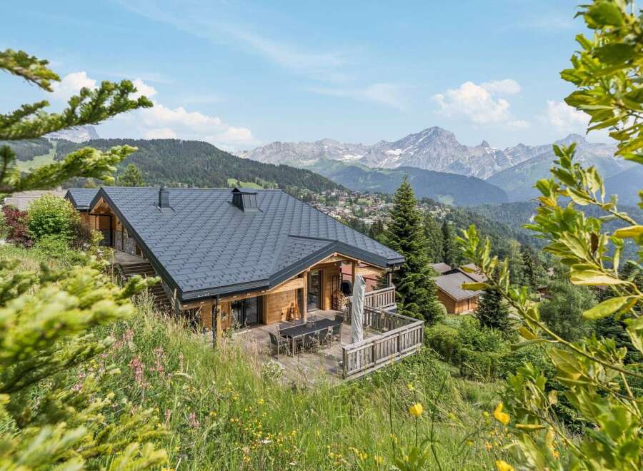 Experience breathtaking mountain views from this stunning wooden chalet, perfectly nestled amidst lush greenery.