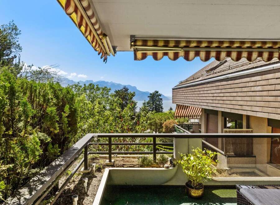 Enjoy breathtaking panoramic views from this stunning balcony, overlooking a serene lake and majestic mountains.