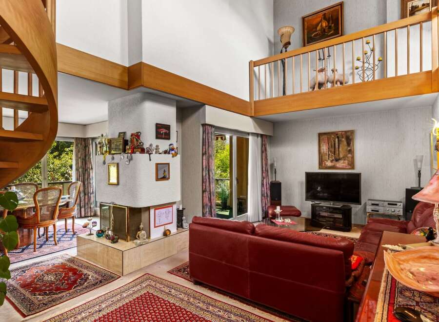 Experience luxurious living in this multi-level home featuring a stunning spiral staircase and a loft overlooking the main living area.