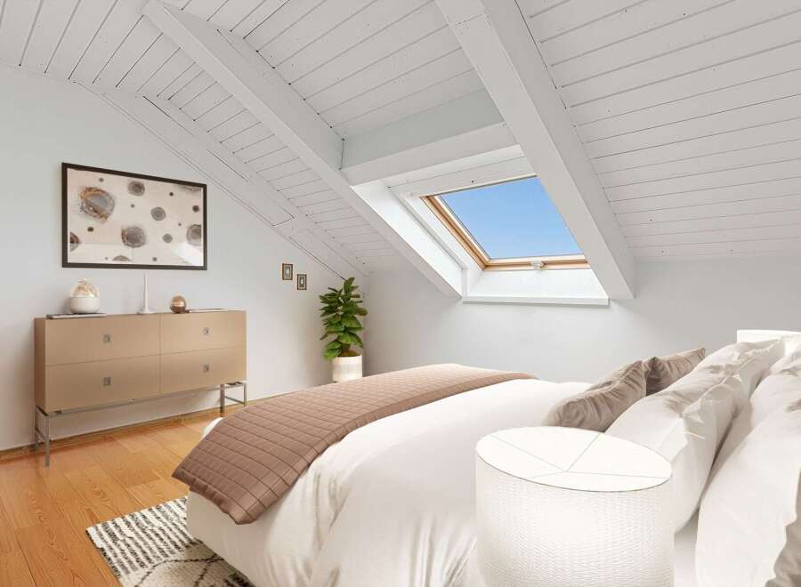 Experience modern living in this charming attic bedroom, featuring a unique sloped ceiling with exposed beams and a large skylight that floods the space with natural light.