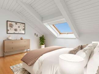 Experience modern living in this charming attic bedroom, featuring a unique sloped ceiling with exposed beams and a large skylight that floods the space with natural light.