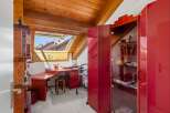 Discover this charming attic workspace, bathed in natural light from a large skylight offering picturesque rooftop views.